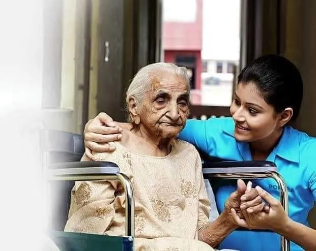 Caretaker attentively assisting an elderly woman in a wheelchair