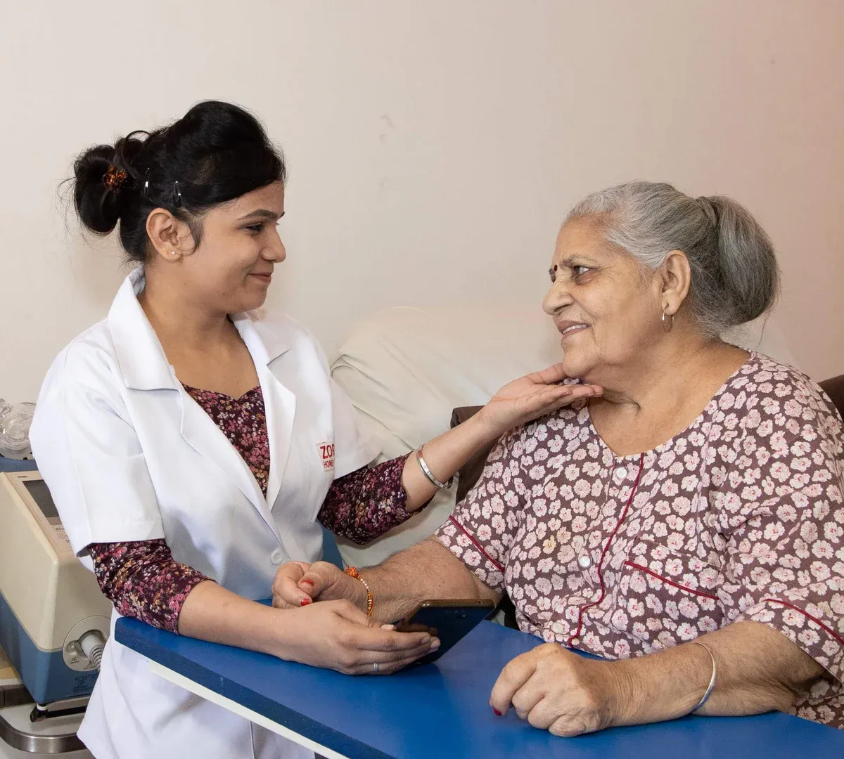 Caretaker attending to an elderly patient at home